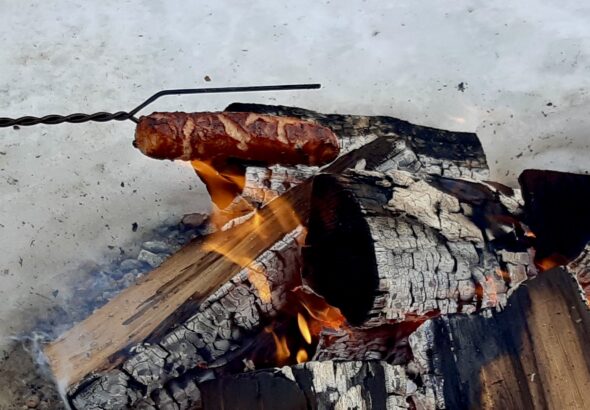 Perfecting the roast: Cooking hotdogs over the crackling community fire at Dyment Recreation Hall today.