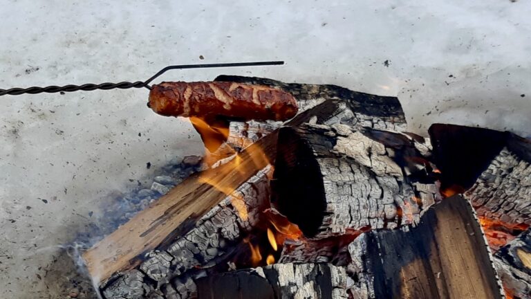 Perfecting the roast: Cooking hotdogs over the crackling community fire at Dyment Recreation Hall today.